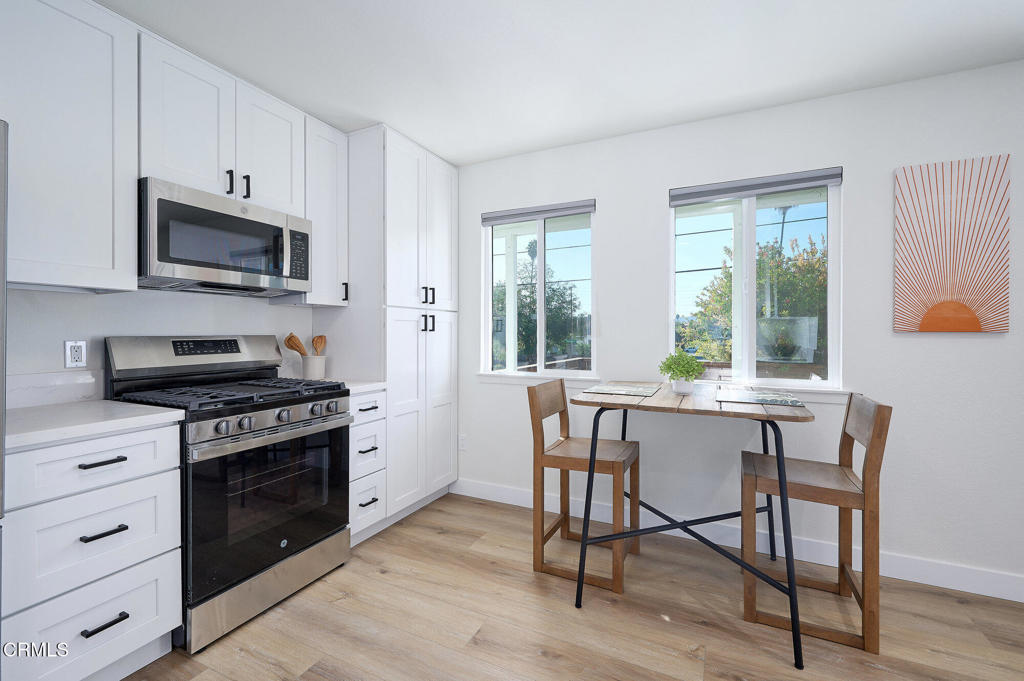 97 Everett Street, Unit B Moorpark, CA 93021 - Photo 12 of 28 a kitchen with stainless steel appliances a stove a sink cabinets and a dining table