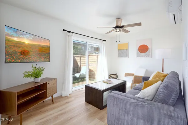 a living room with furniture ceiling fan and a window