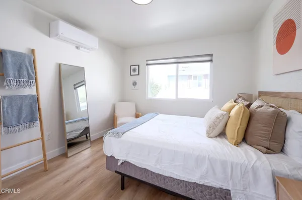 a bedroom with a bed and a refrigerator