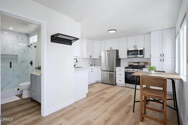 a kitchen with white cabinets and stainless steel appliances