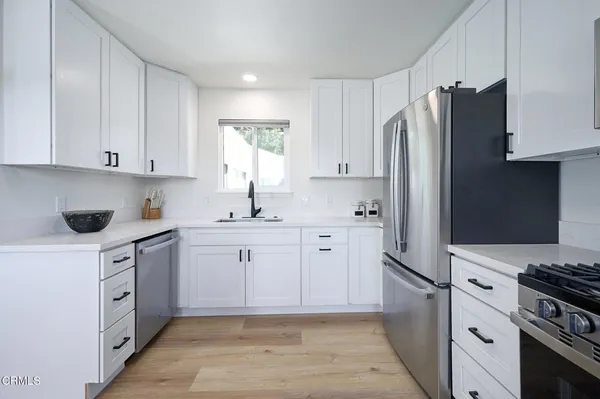 a kitchen with stainless steel appliances a refrigerator sink and cabinets