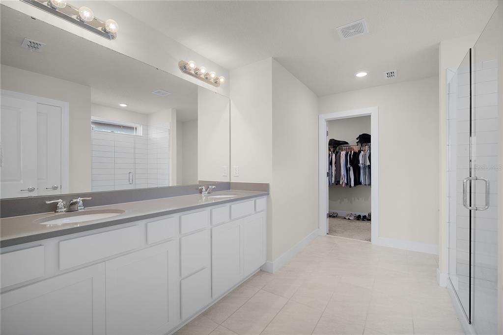 7379 Catania Loop Clermont, FL 34714 - Photo 20 of 37 a bathroom with a double vanity sink and a mirror