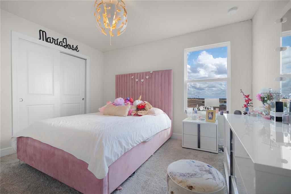 7379 Catania Loop Clermont, FL 34714 - Photo 22 of 37 a bedroom with a bed and a chandelier