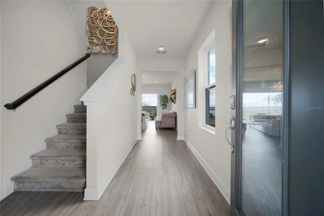 a view of a hallway with wooden floor and staircase