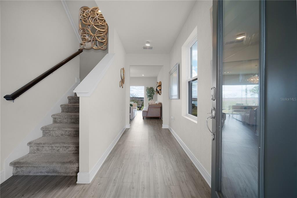 7379 Catania Loop Clermont, FL 34714 - Photo 5 of 37 a view of a hallway with wooden floor and staircase
