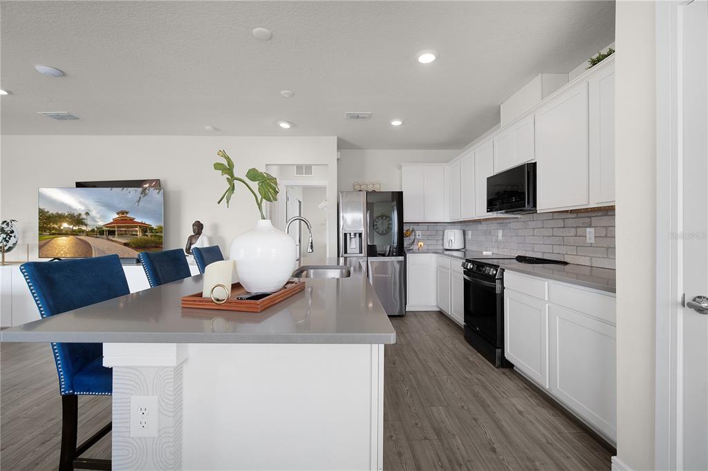 7379 Catania Loop Clermont, FL 34714 - Photo 8 of 37 a kitchen with a stove a sink and a refrigerator