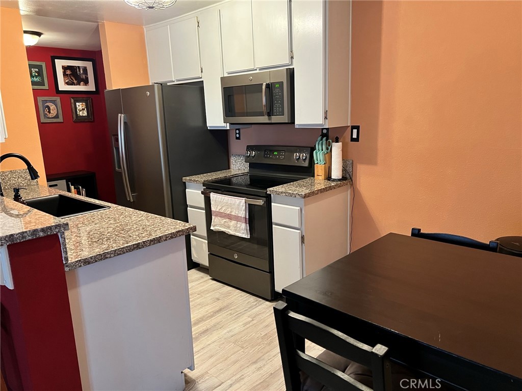 1723 Cedar Avenue, Unit 102 Long Beach, CA 90813 - Photo 8 of 22 a kitchen with stainless steel appliances a refrigerator and a stove top oven