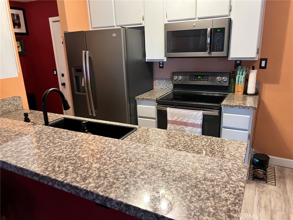 1723 Cedar Avenue, Unit 102 Long Beach, CA 90813 - Photo 10 of 22 a kitchen with kitchen island granite countertop a refrigerator and a stove top oven