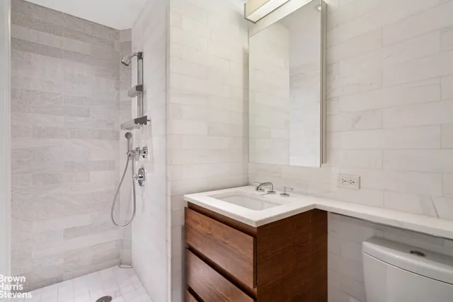 a bathroom with a sink vanity and shower