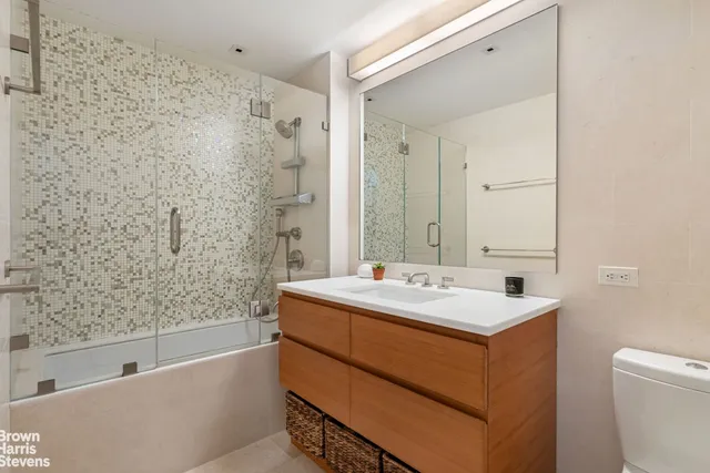 a bathroom with a sink a toilet and shower