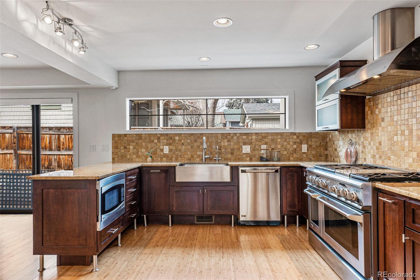 422 Cook Street Denver, CO 80206 - Photo 11 of 40 a kitchen with stainless steel appliances granite countertop a stove and a sink