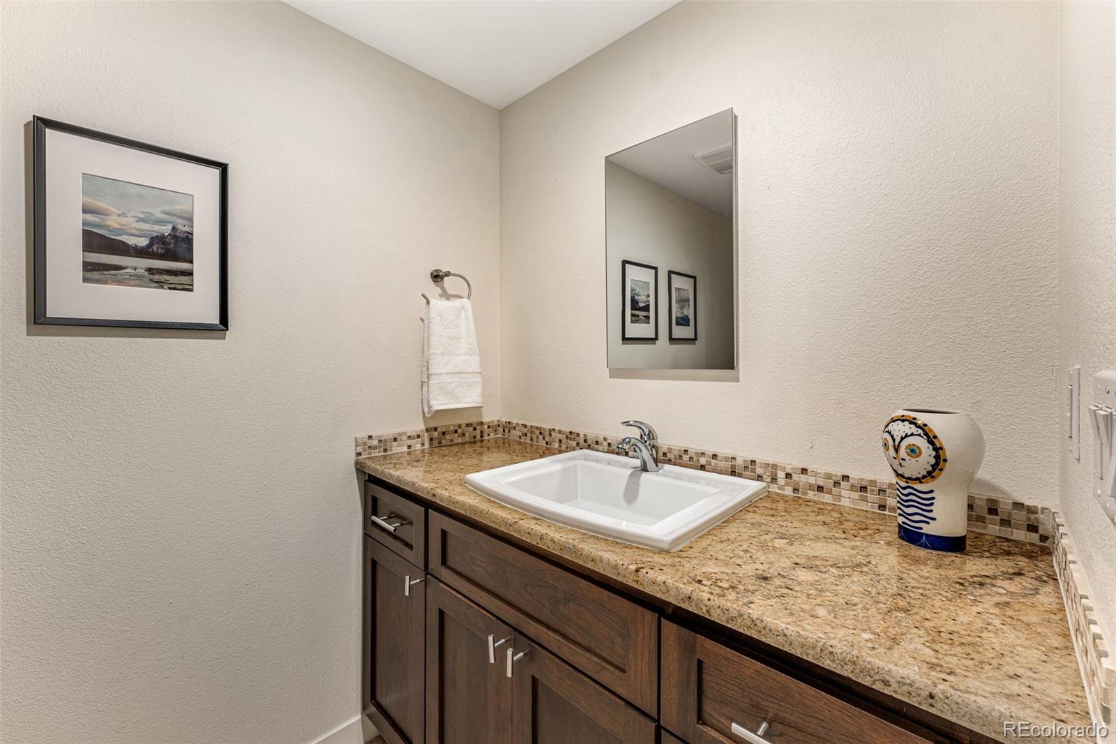 422 Cook Street Denver, CO 80206 - Photo 37 of 40 a bathroom with a granite countertop sink and a mirror