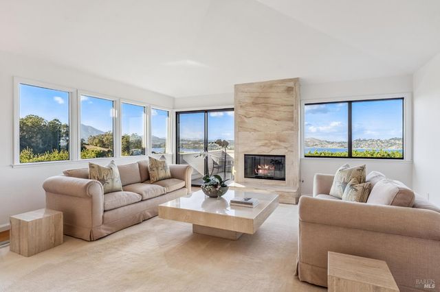 a living room with furniture fireplace and a large window