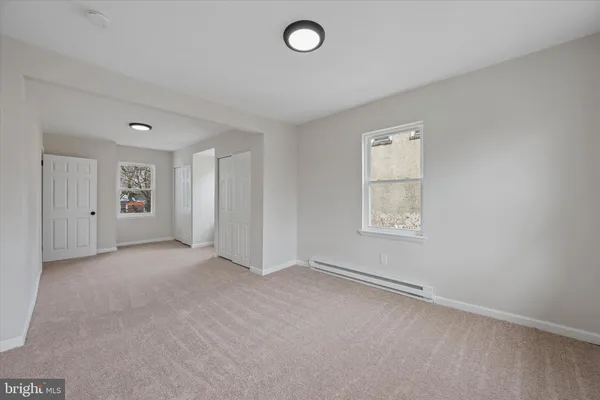 an empty room with windows and closet