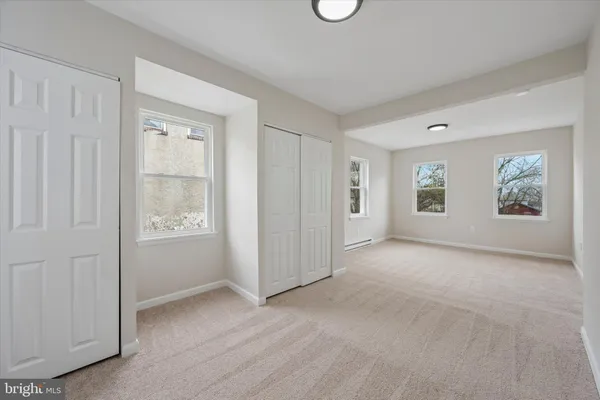 an empty room with windows and closet