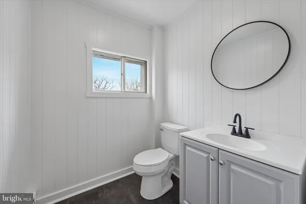a bathroom with a toilet a sink and a mirror