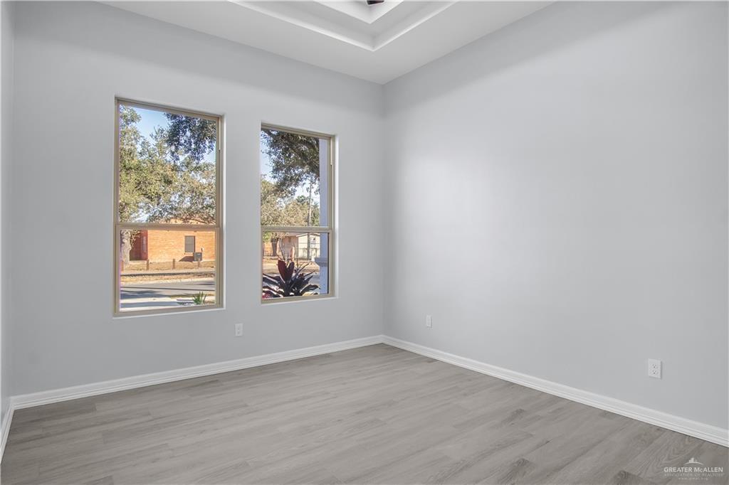 607 North 9th Street Alamo, TX 78516 - Photo 13 of 24 an empty room with wooden floor and windows