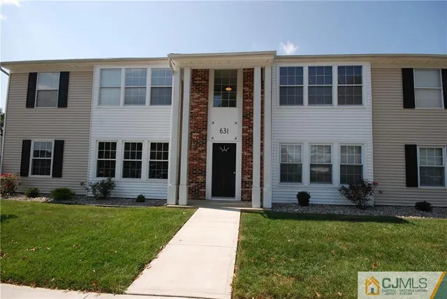 front view of a brick house with a yard
