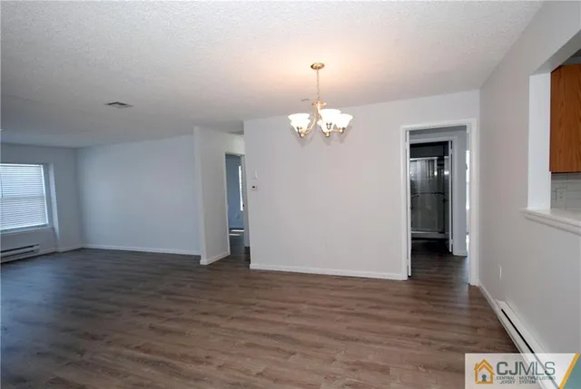 an empty room with wooden floor and window