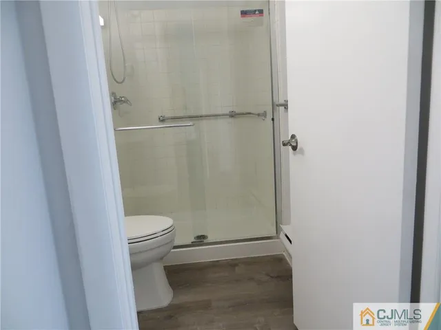 a bathroom with a granite countertop toilet and a shower