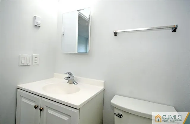 a bathroom with a sink toilet and a mirror
