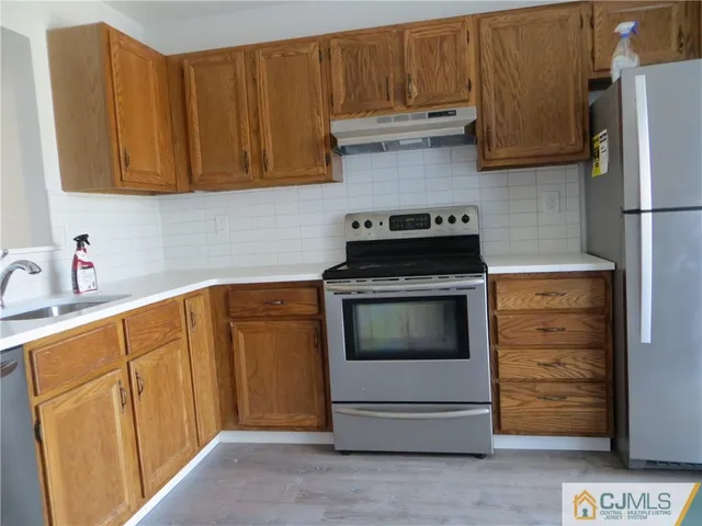 a kitchen with stainless steel appliances wooden cabinets and a stove top oven