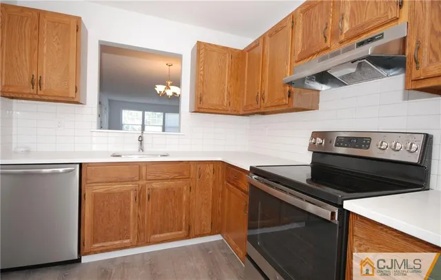 a kitchen with stainless steel appliances a stove a sink and cabinets