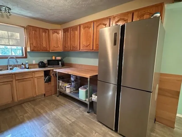 a kitchen with stainless steel appliances granite countertop a refrigerator a sink and a stove