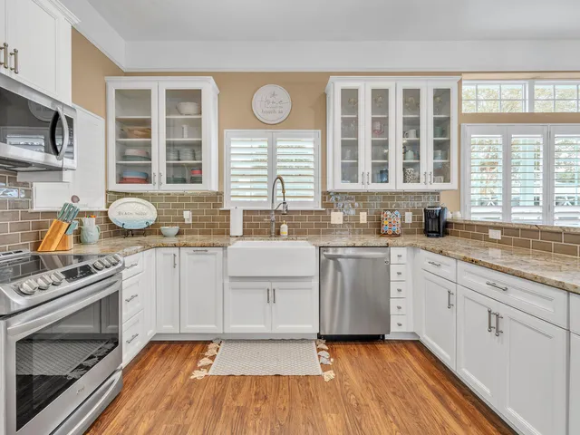 a kitchen with stainless steel appliances granite countertop a stove and white cabinets