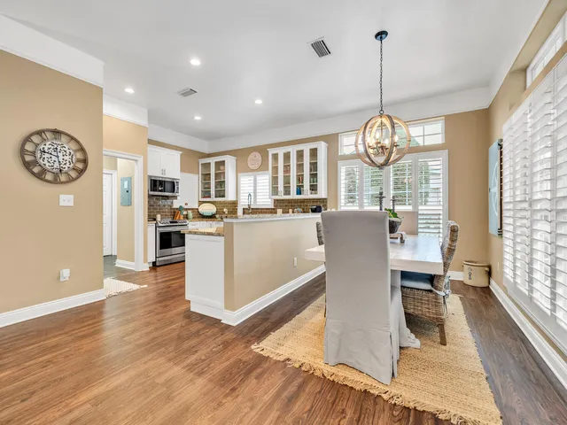 a view of a dining room and livingroom with furniture wooden floor a chandelier