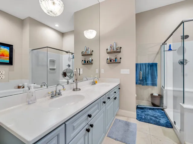 a spacious bathroom with a sink double vanity granite and a mirror