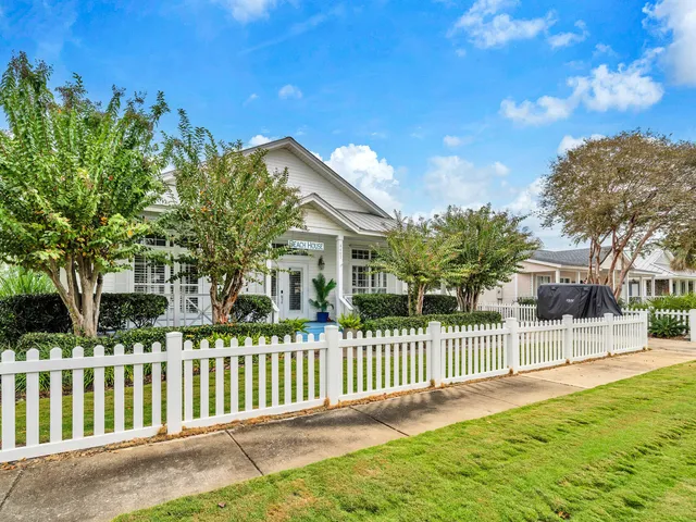 a view of a house with a small yard and fence