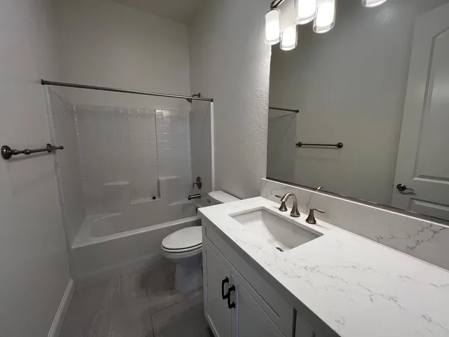 a bathroom with a sink a toilet a mirror and shower