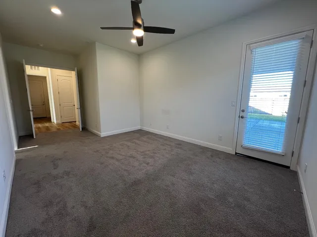 an empty room with chandelier fan