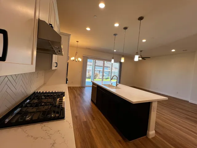 a kitchen with stainless steel appliances granite countertop a stove a sink and a refrigerator