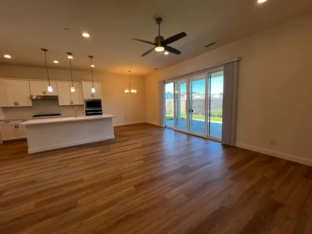 an open kitchen view with wooden floor and a large window