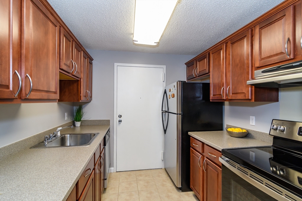 46 Silver Hill Lane, Unit 1 Natick, MA 01760 - Photo 5 of 11 a kitchen view with stainless steel appliances granite countertop a sink stove and refrigerator