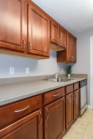 a kitchen with granite countertop stainless steel appliances a sink and cabinets