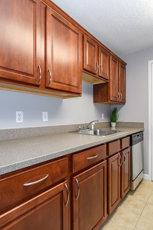 46 Silver Hill Lane, Unit 1 Natick, MA 01760 - Photo 8 of 11 a kitchen with granite countertop stainless steel appliances a sink and cabinets