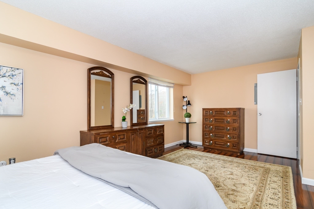 46 Silver Hill Lane, Unit 1 Natick, MA 01760 - Photo 10 of 11 a bedroom with a bed and dresser with mirror