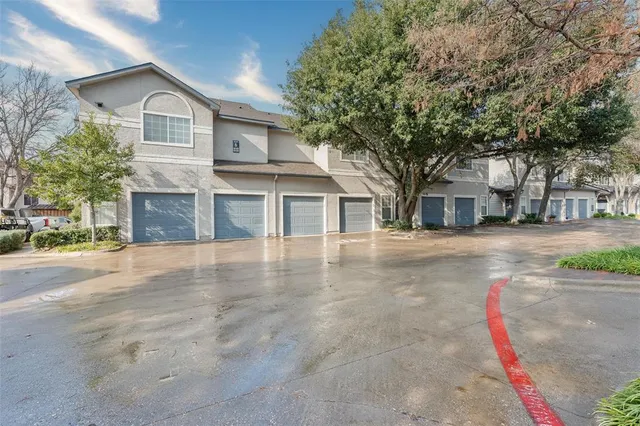 a view of a house with a large tree and a yard