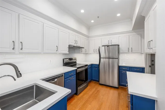 a kitchen with stainless steel appliances a refrigerator sink and cabinets