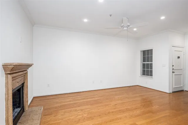 a view of an empty room with a fireplace and fan