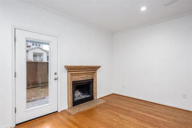 a view of empty room with wooden floor and fireplace