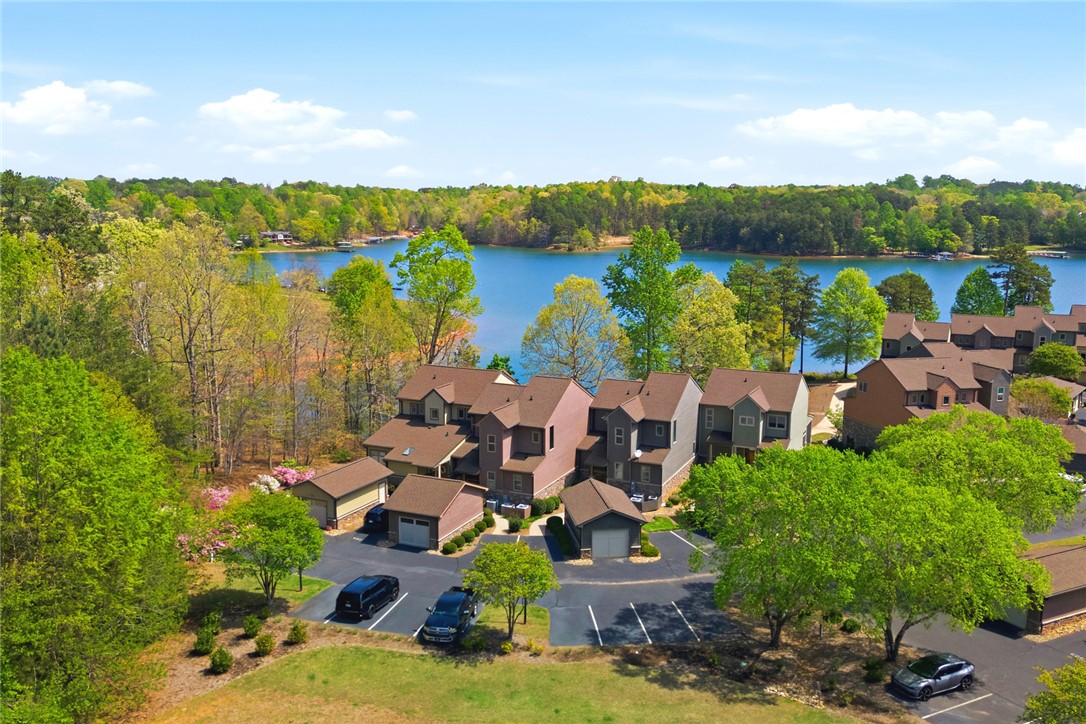 578 Sunset Point Drive West Union, SC 29696 - Photo 37 of 46 An aerial view captures a serene lakeside community surrounded by lush trees and clear blue water.