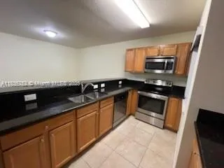 a kitchen with granite countertop a sink and steel appliances