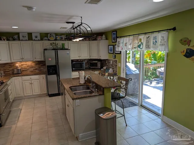 a kitchen with stainless steel appliances granite countertop a sink and a stove