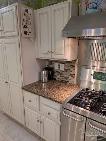 a kitchen with granite countertop a sink stove and cabinets