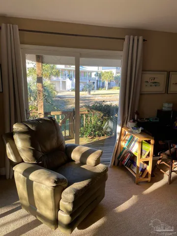 a living room with furniture a flat screen tv and a floor to ceiling window