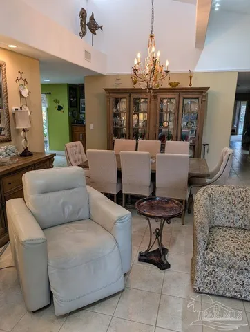 a living room with patio furniture and a chandelier